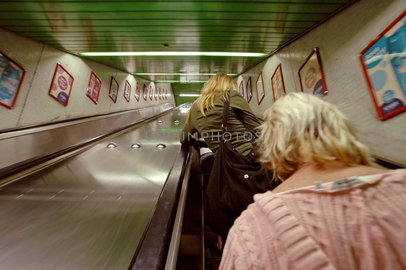 two women going up on an escalator,