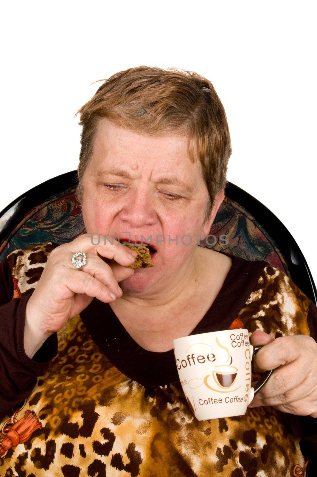 elderly woman is drinking coffee and eating a cookie isolated on white