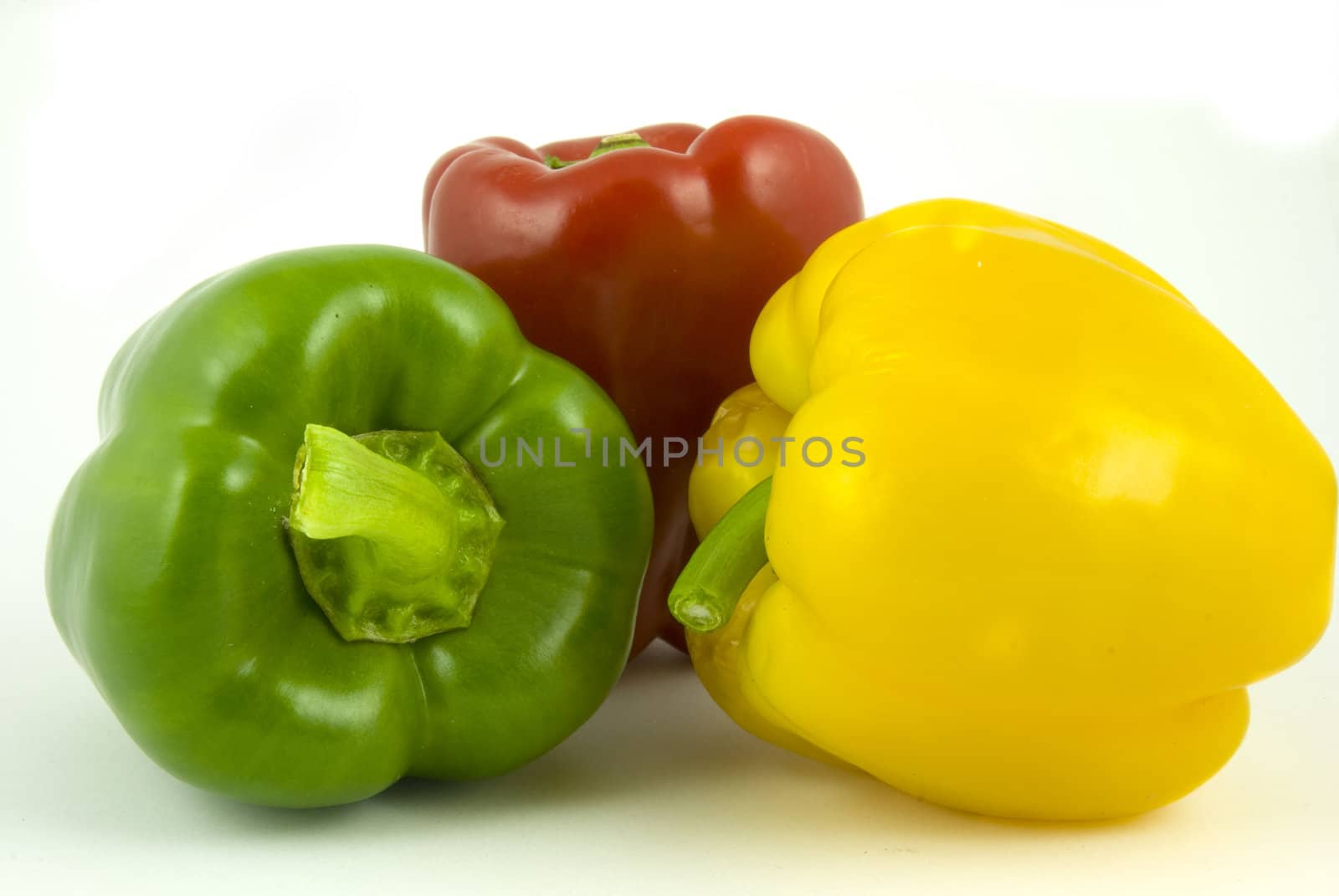 Yellow and green and red bell peppers isolated on white background