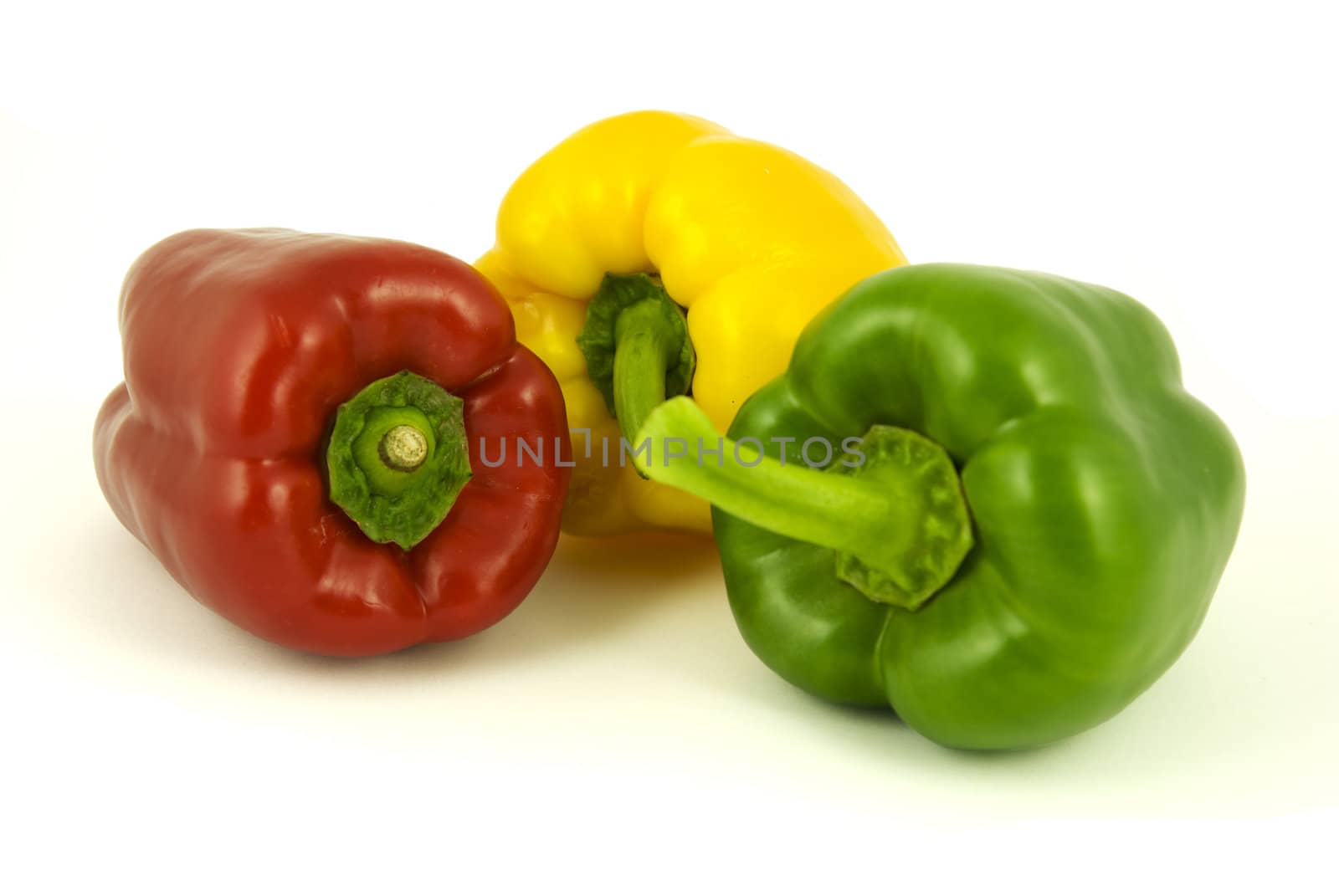 Yellow and green and red bell peppers isolated on white background