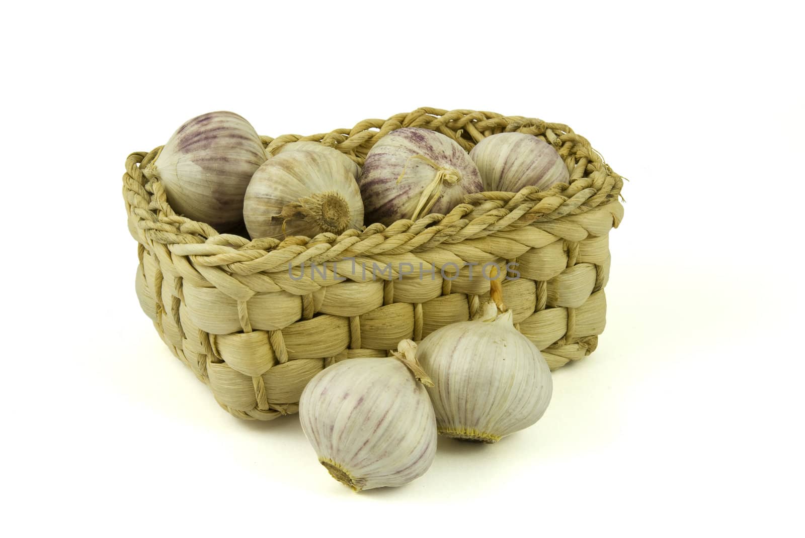 Basket full of fresh garlics isolated on white background