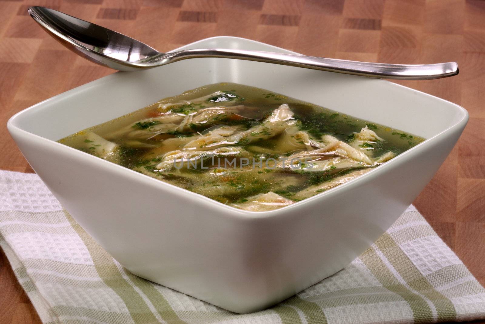 chicken breast and vegetables soup  made with low sodium  broth,  on fine wood table table.