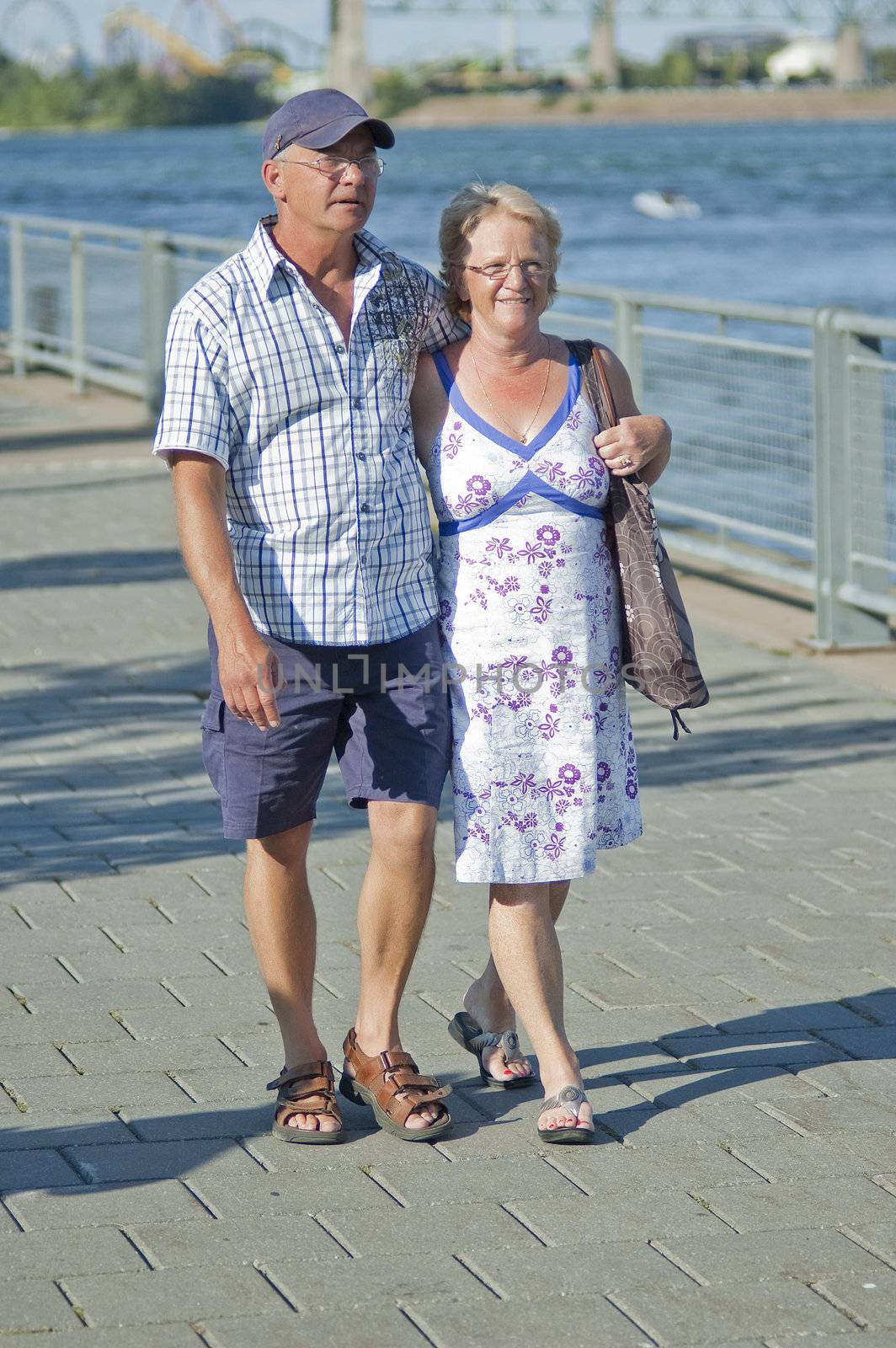 Aged loving couple walking and holding each other 