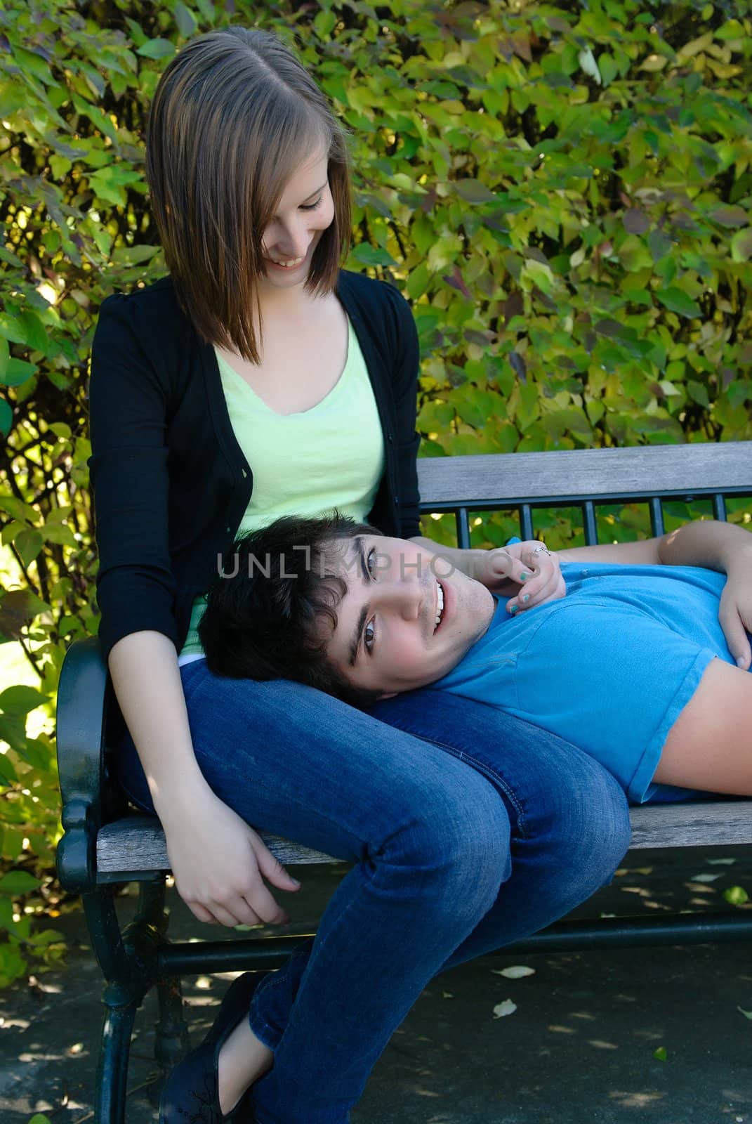 A young teen lying on his girlfriend's lap