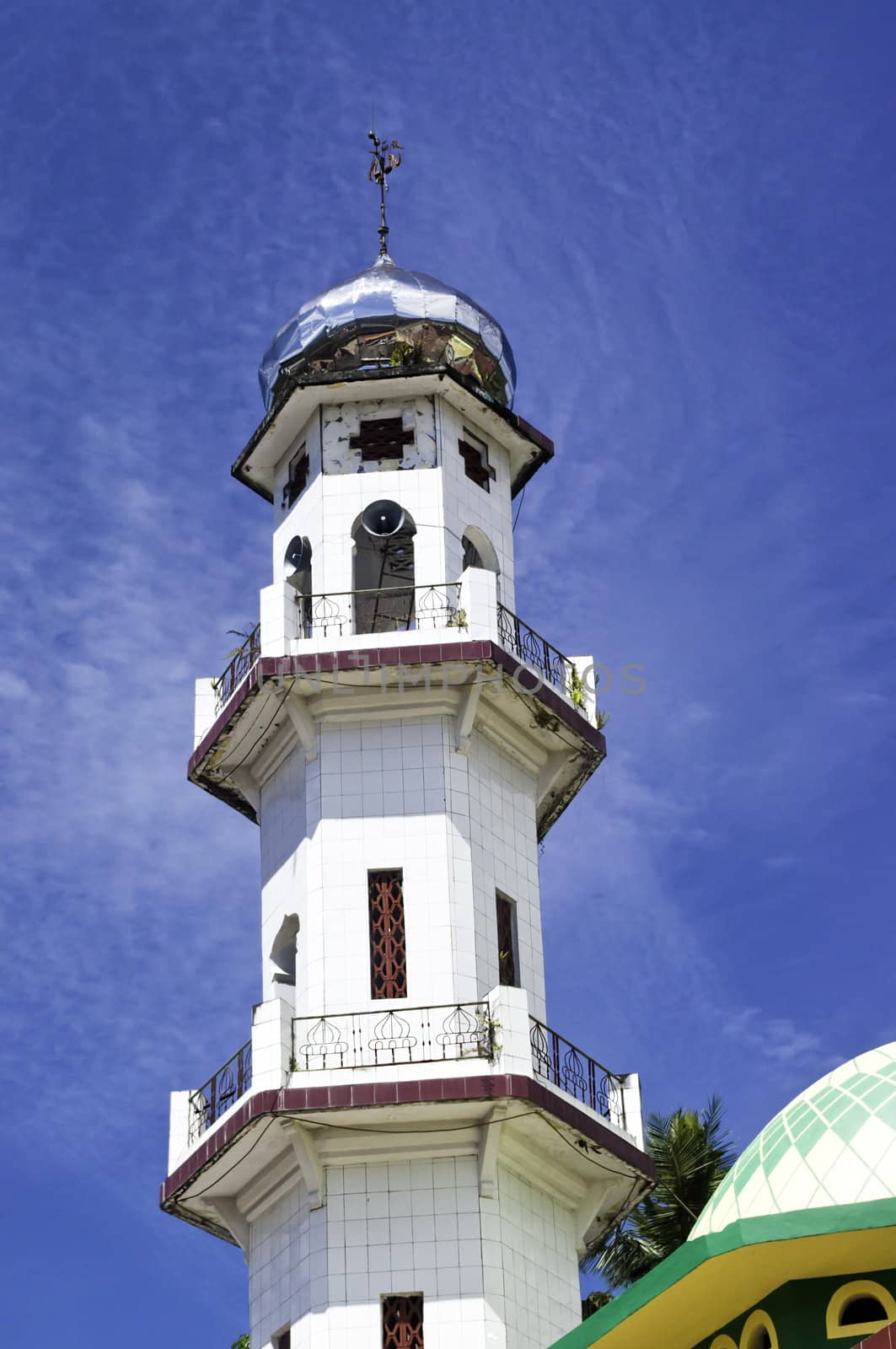 Modern mosque minaret in sulawasi Indonesia over a blue cloudy sky