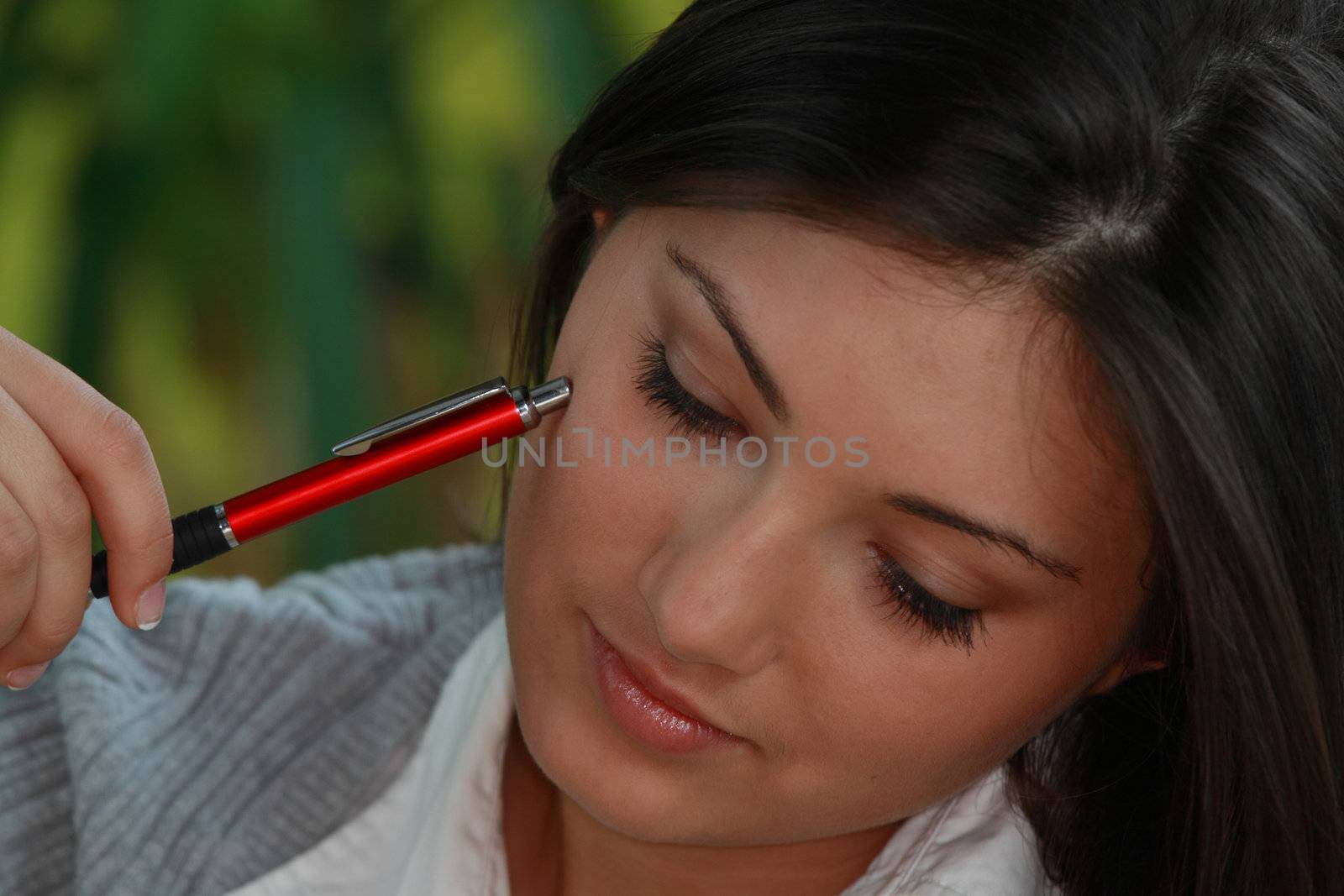 Young beautieful, natural looking, caucasian, brunette girl learning on the flor with red pen and books
