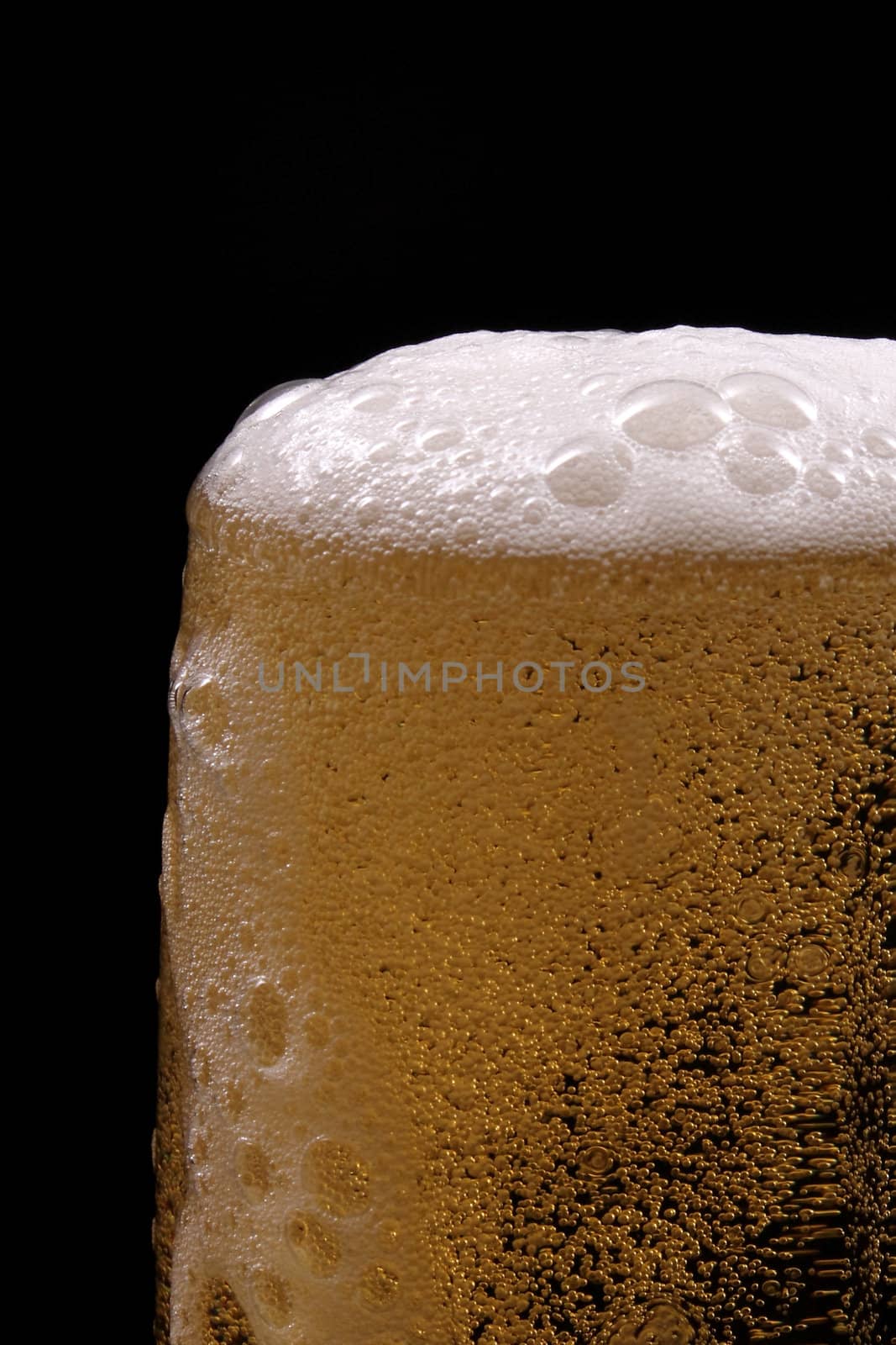 A glass of beer against black background 
