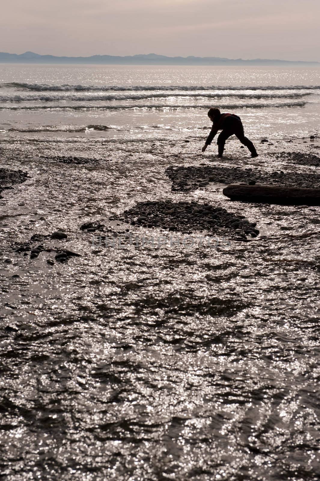 young boy playing in water by rongreer