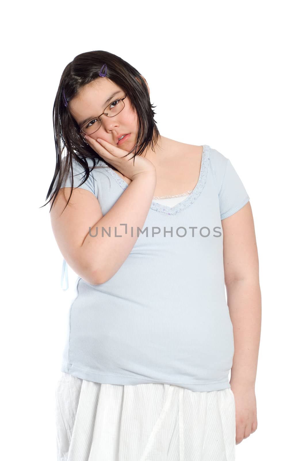 A young girl standing with her hand on her mouth, suffering from a sore tooth, isolated against a white backround