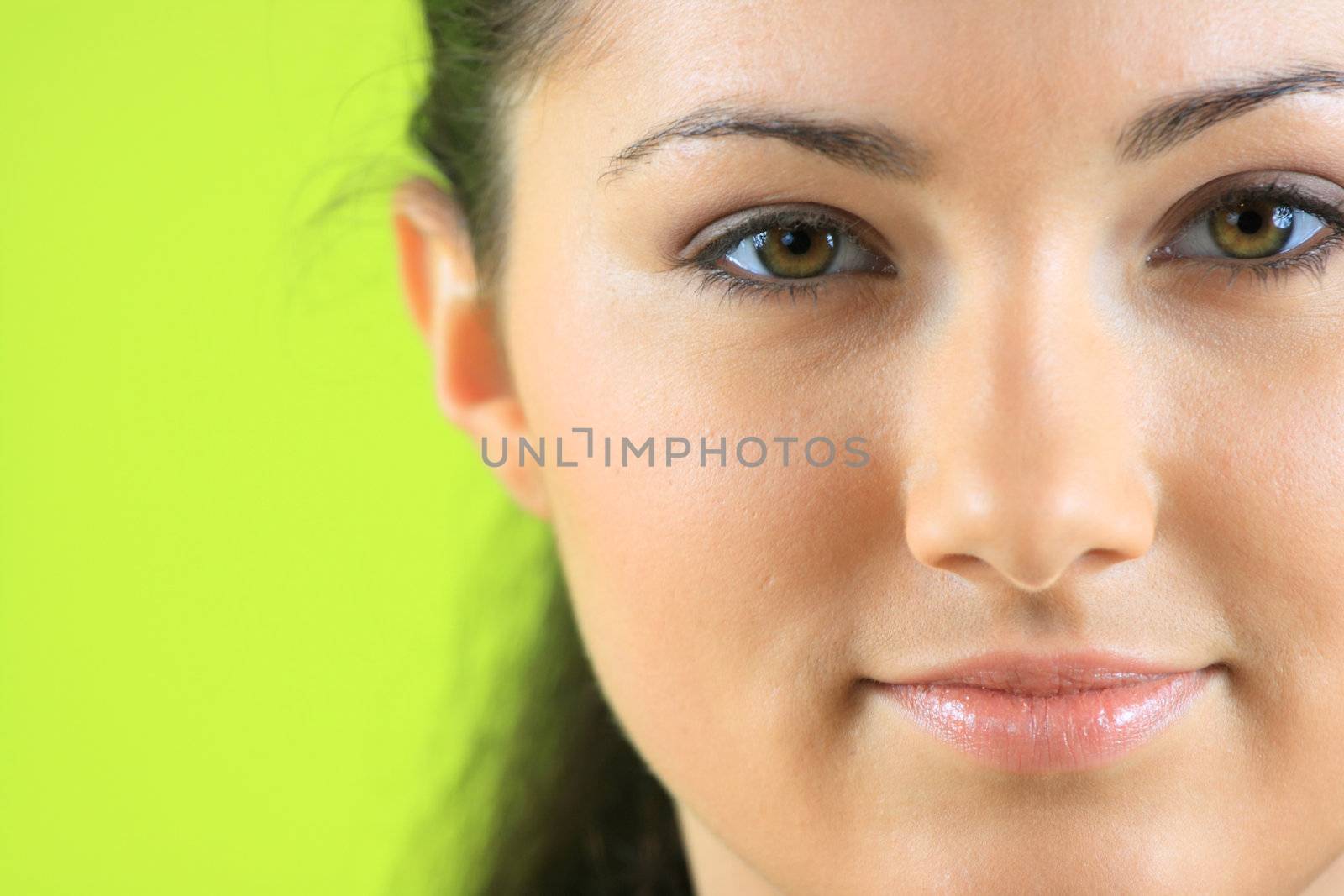 Closeup portrait of a happy young woman over green