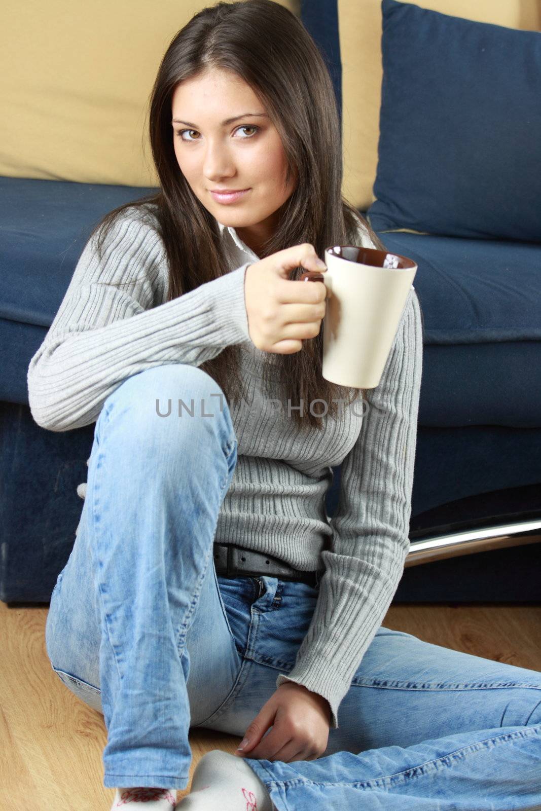 Young woman with beautiful face is having her tea/coffee