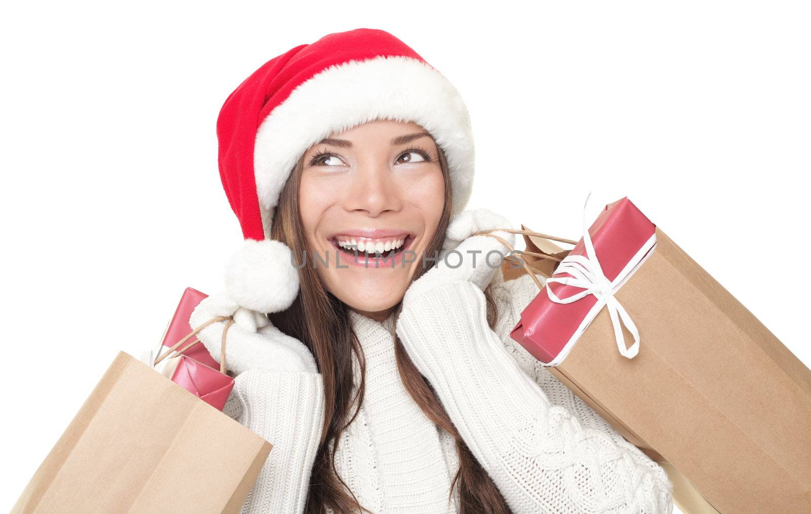 Christmas shopping advertisement woman thinking looking up at copy-space. Isolated head and shoulder portrait of shopper with gift bags. White background.
