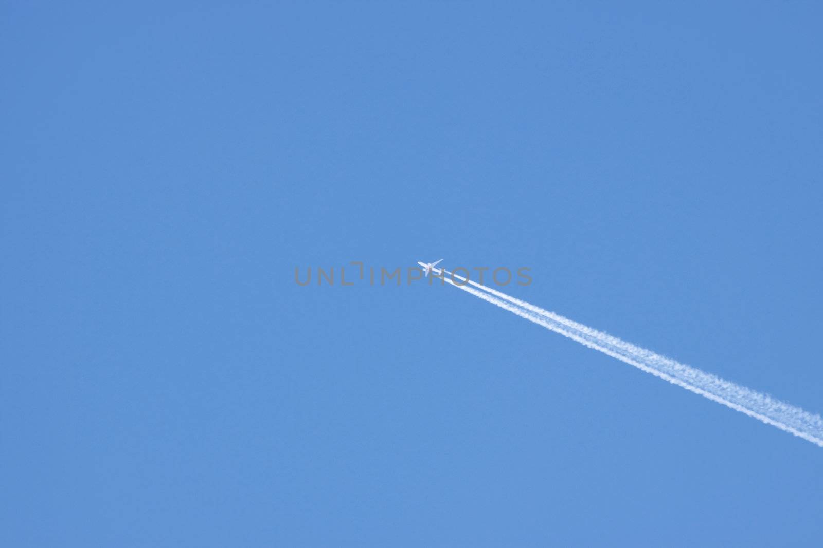Jet airplane on almost clear blue sky witch some clouds