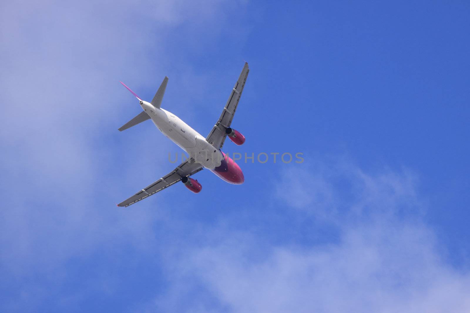 Jet airplane on almost clear blue sky witch some clouds