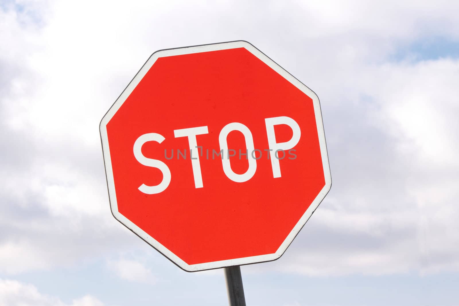 Road sign - stop - on cloudy sky background