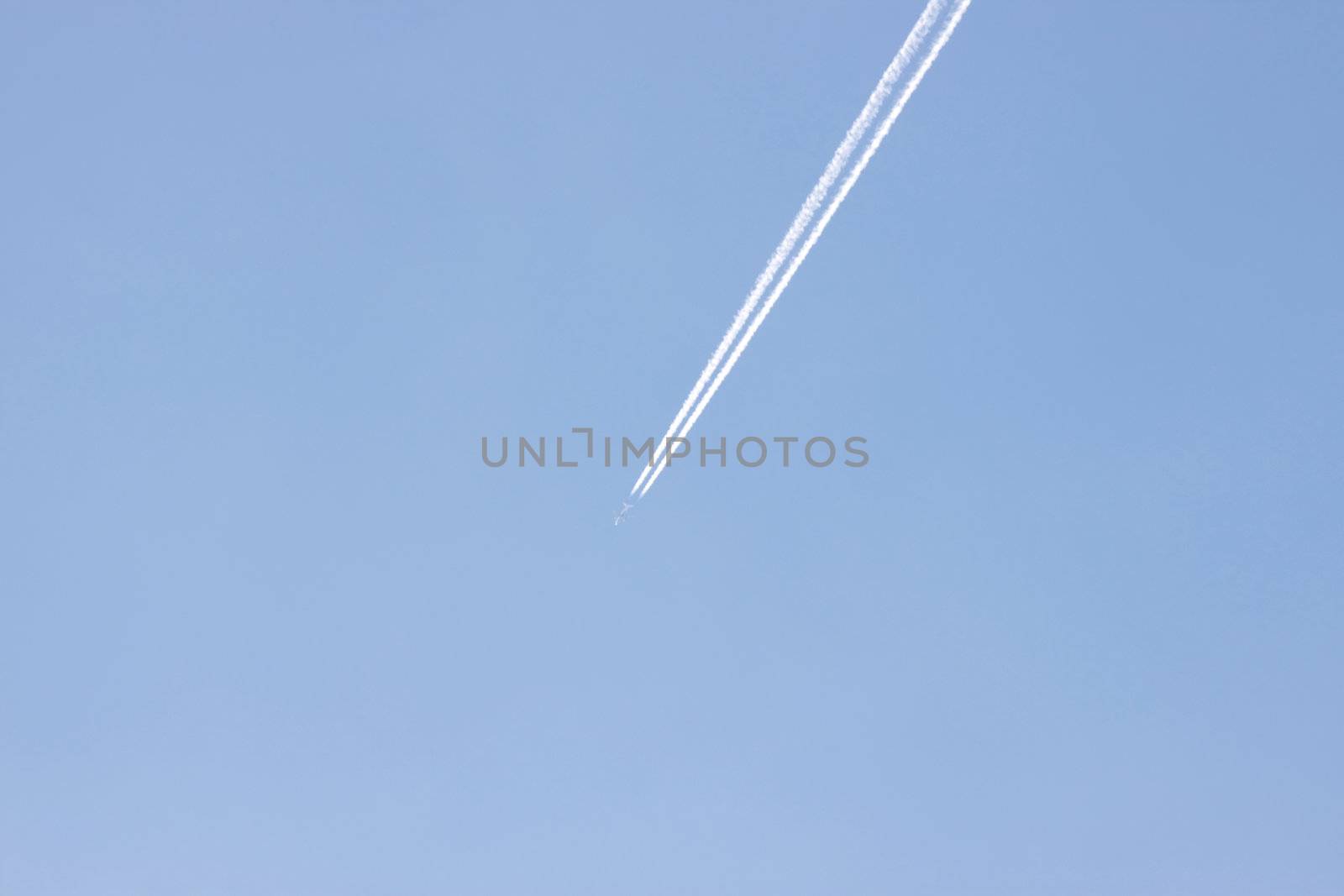 Jet airplane on almost clear blue sky witch some clouds