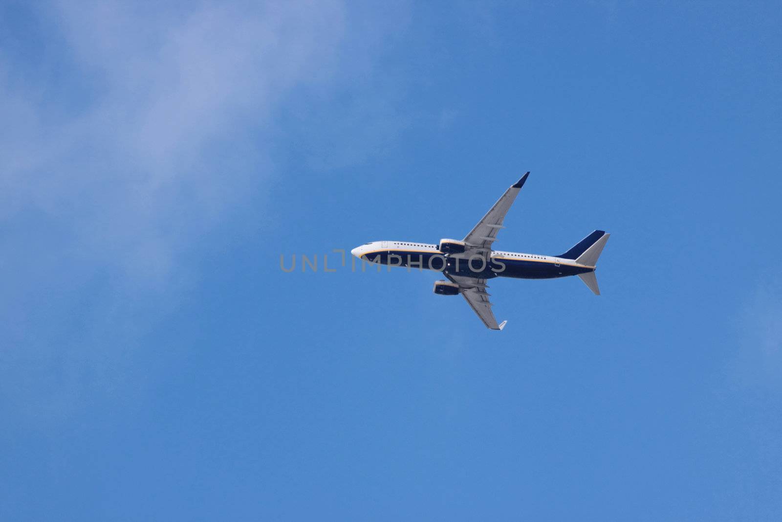 Jet airplane on almost clear blue sky witch some clouds