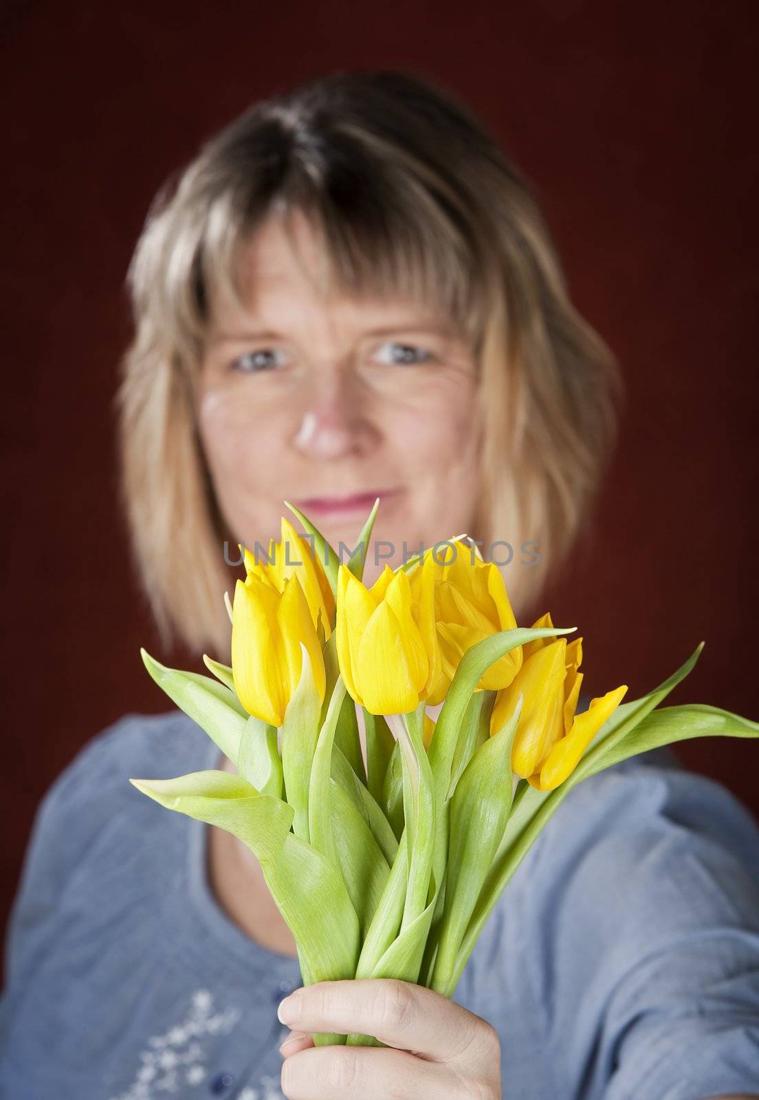 Pretty woman with a bunch of yellow tulips