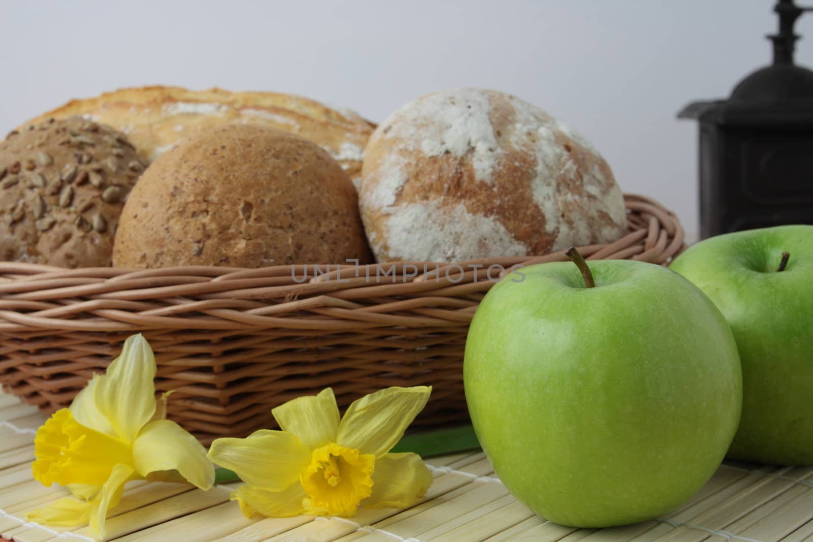 Variety of whole wheat bread in basket and greena apples