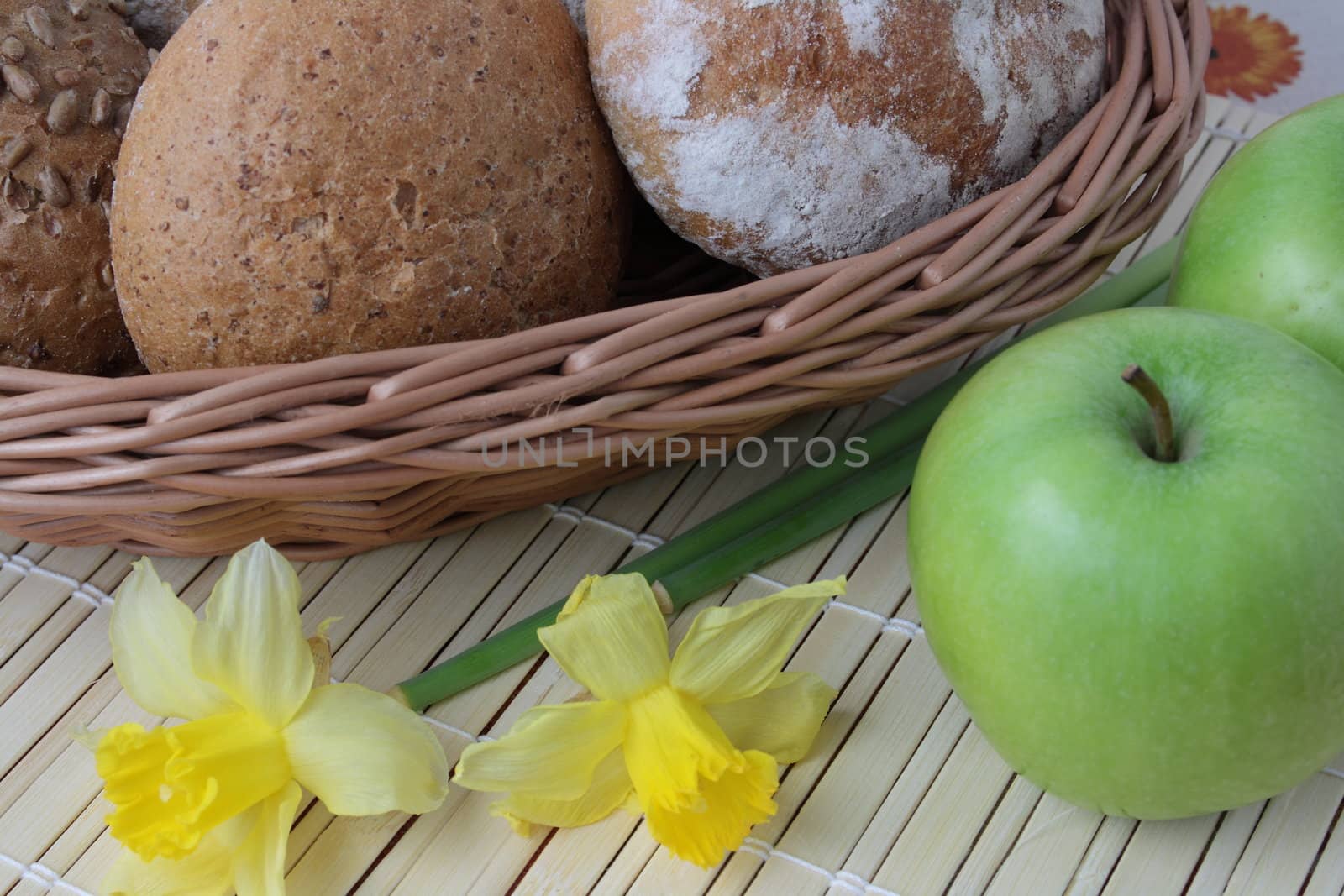 Variety of whole wheat bread in basket and greena apples