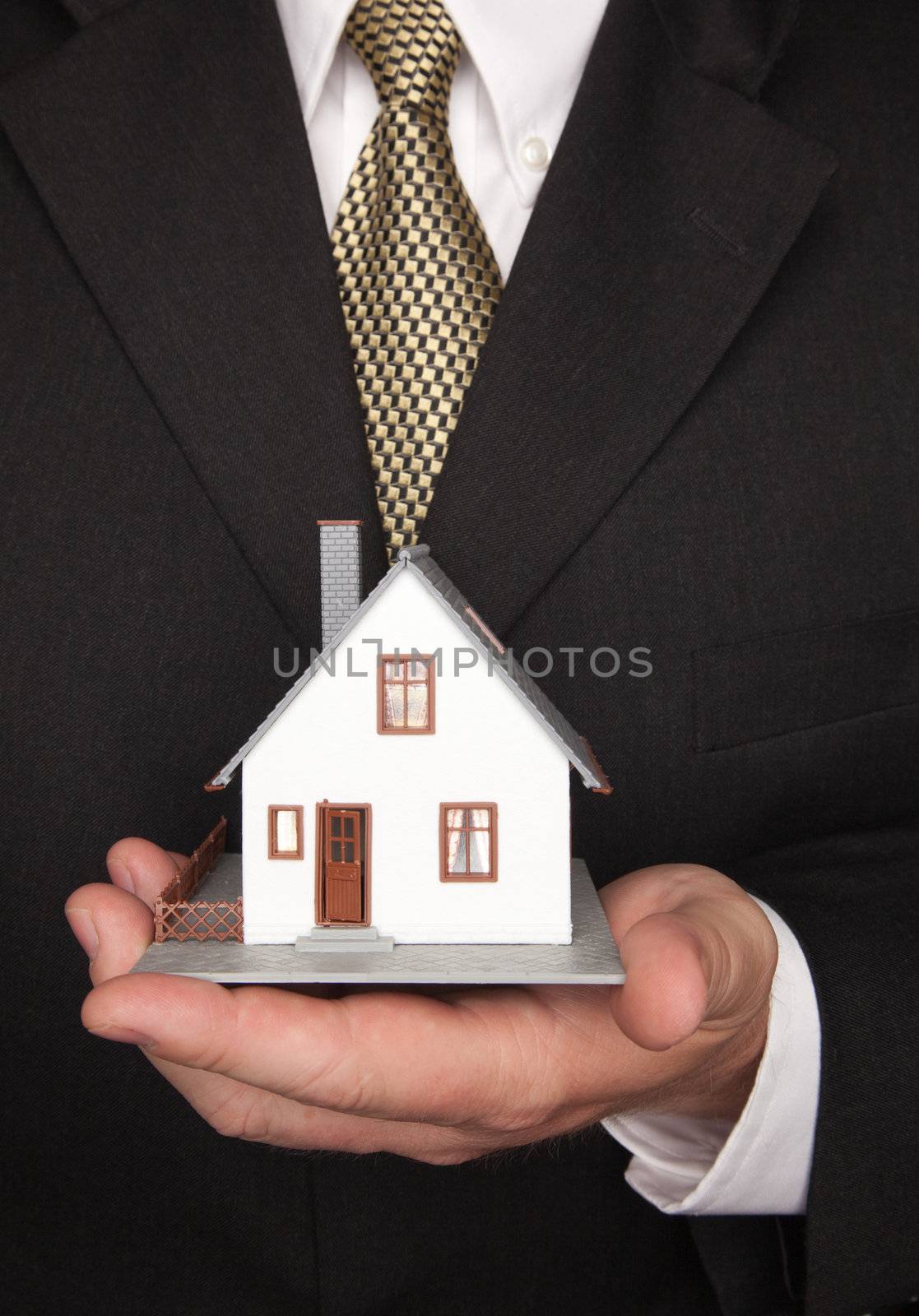 Businessman with Coat and Tie Holding House.