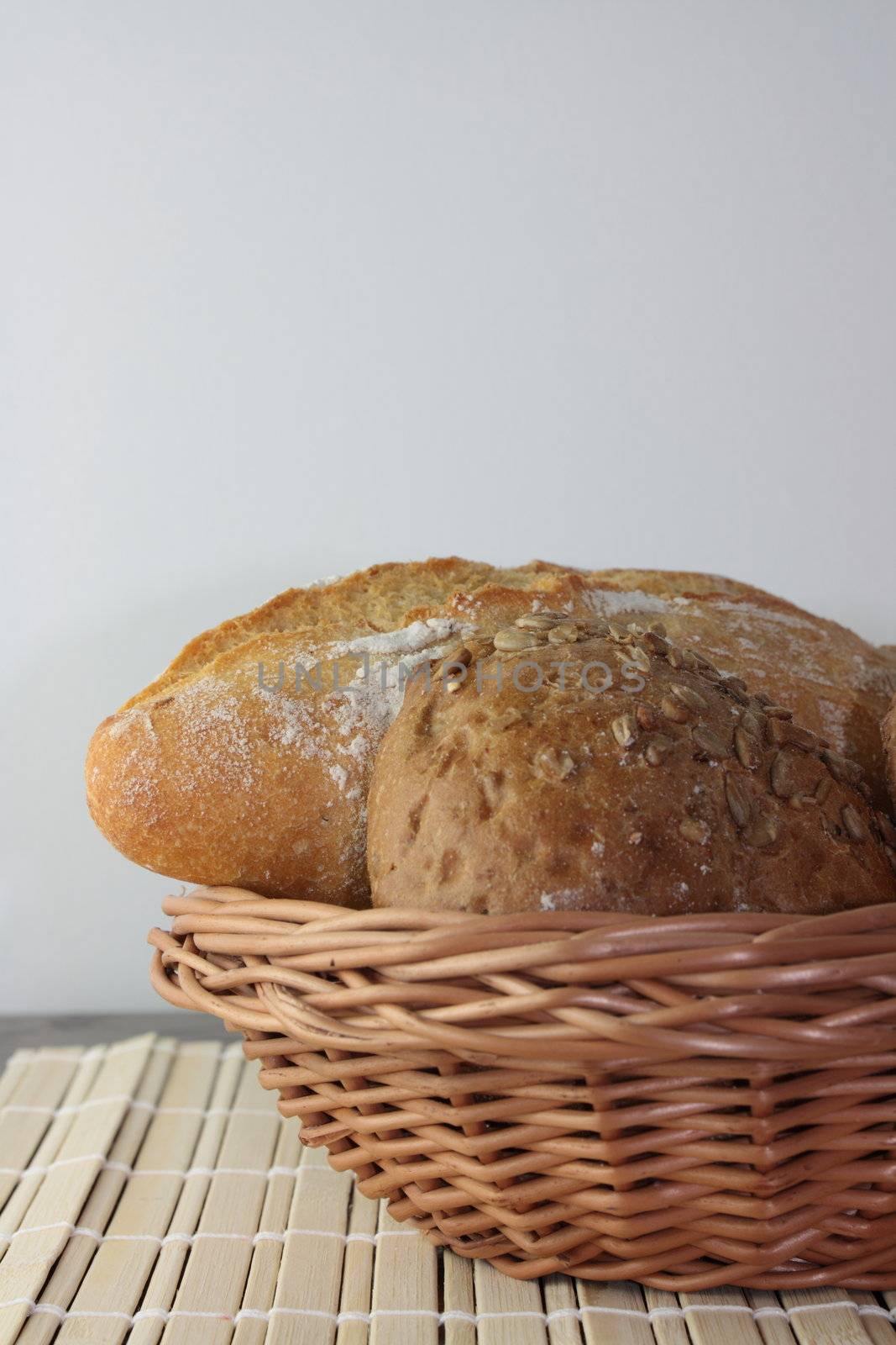 Basket of various fresh baked bread on wooden table