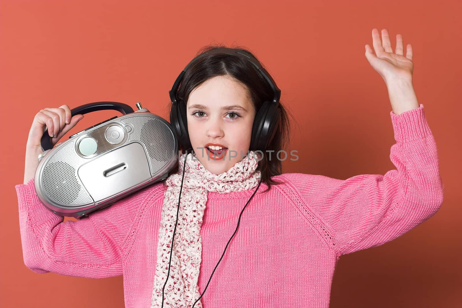 pretty girl listening music with headphones and holding portable CD radio