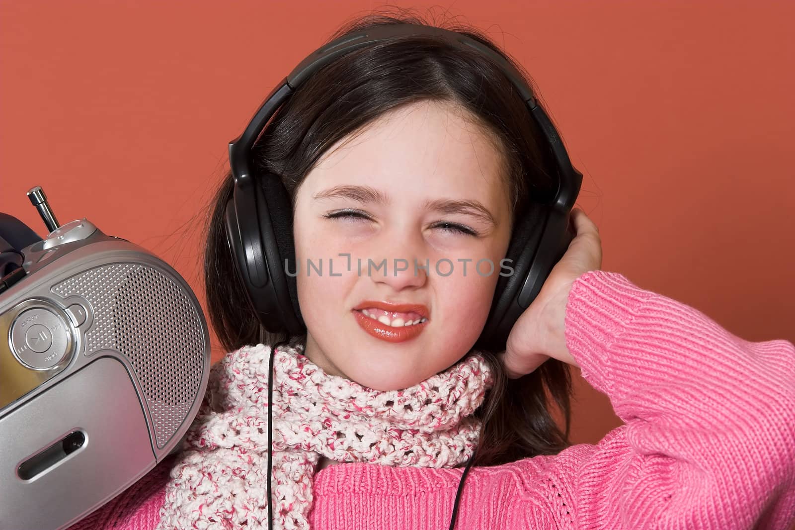 pretty girl listening music with headphones and holding portable CD radio