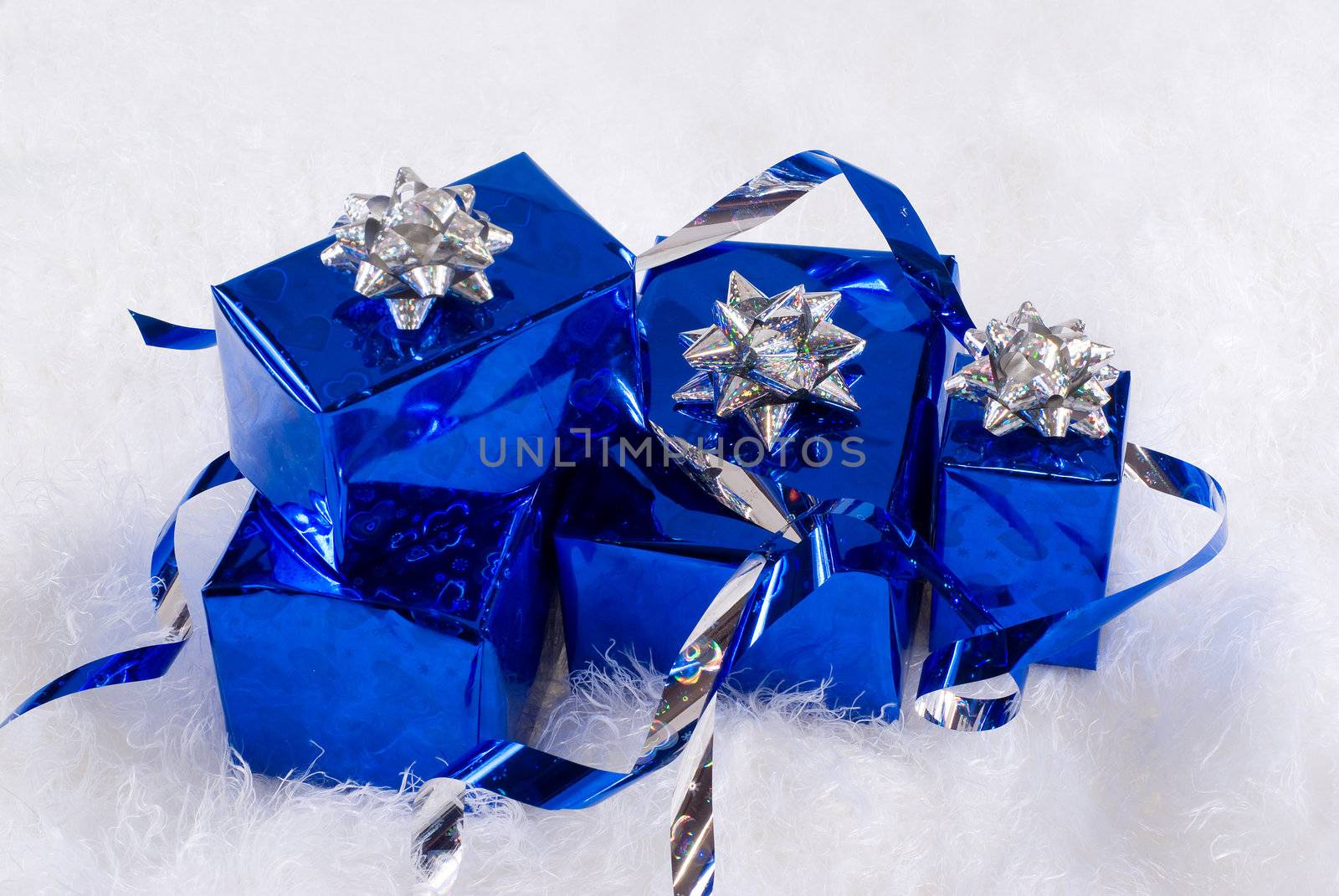 Blue shiny boxes for gifts with silver ribbons on the white skin