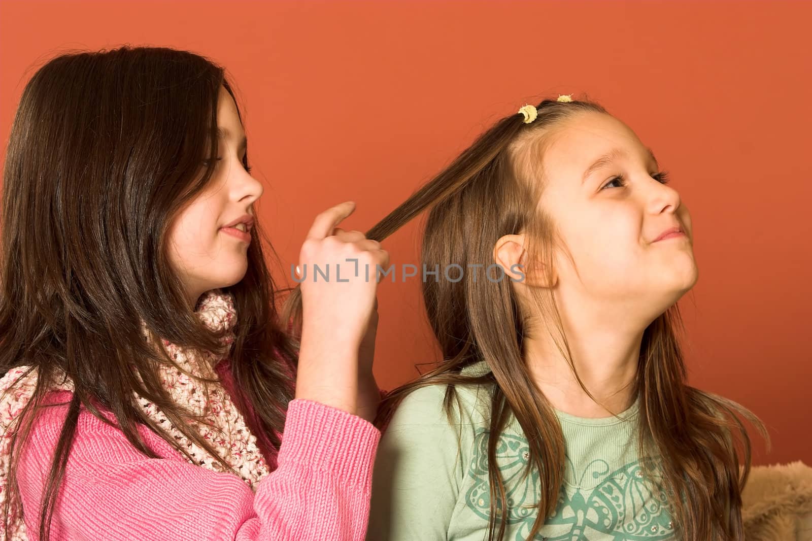 two pretty girls touching hair