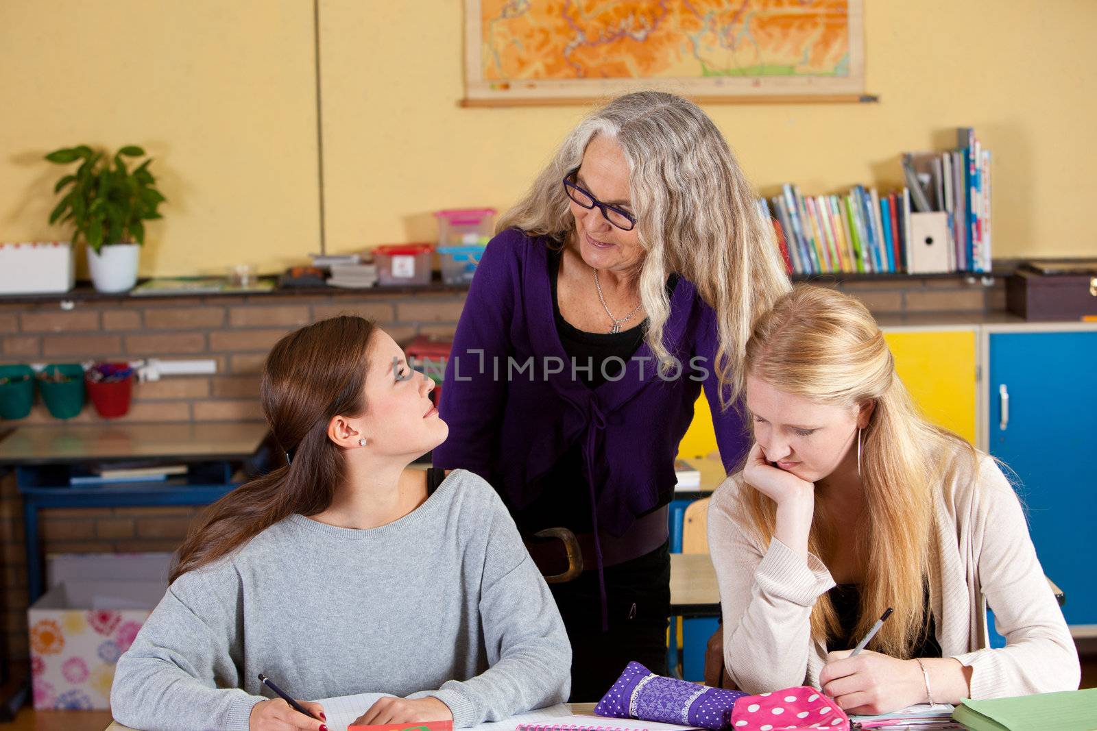 Teacher checking up on her students in the classroom