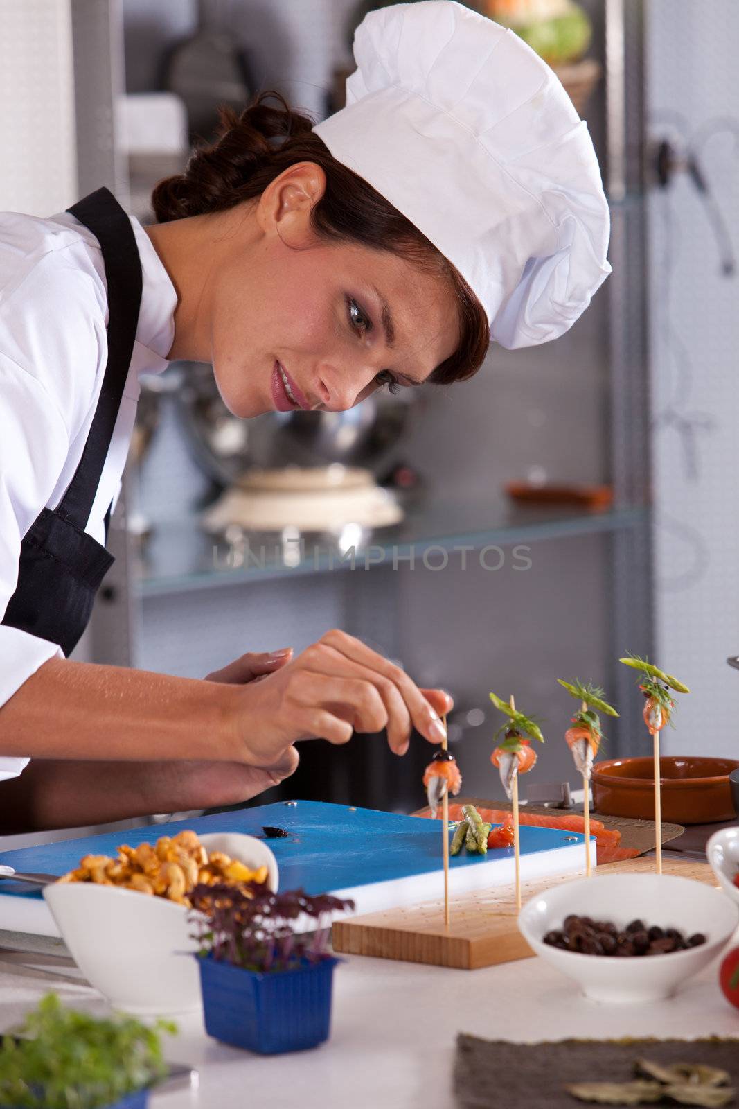 Young female chef adding the finishing touch to her amuse