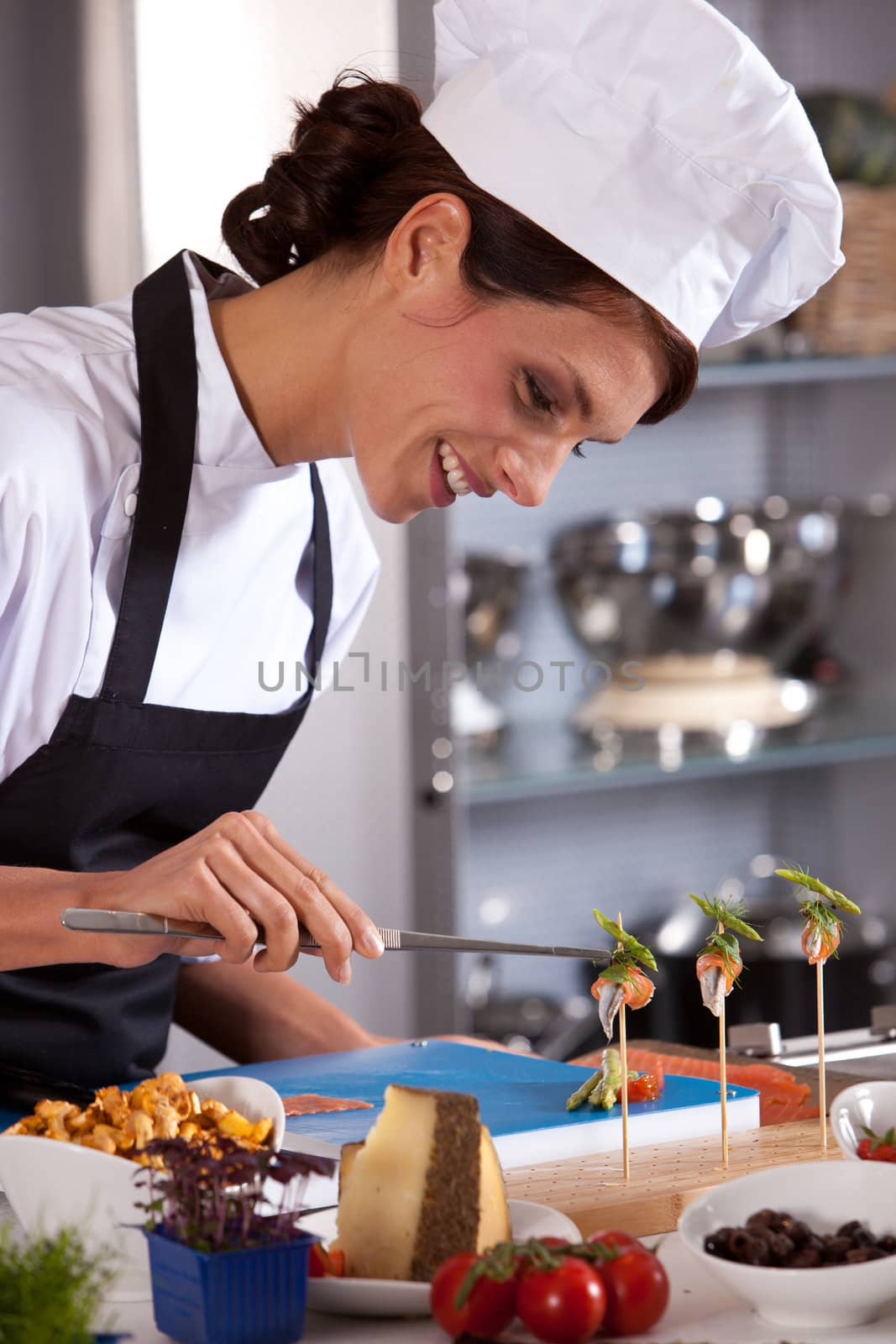 Attractive and happy female chef preparing an amuse
