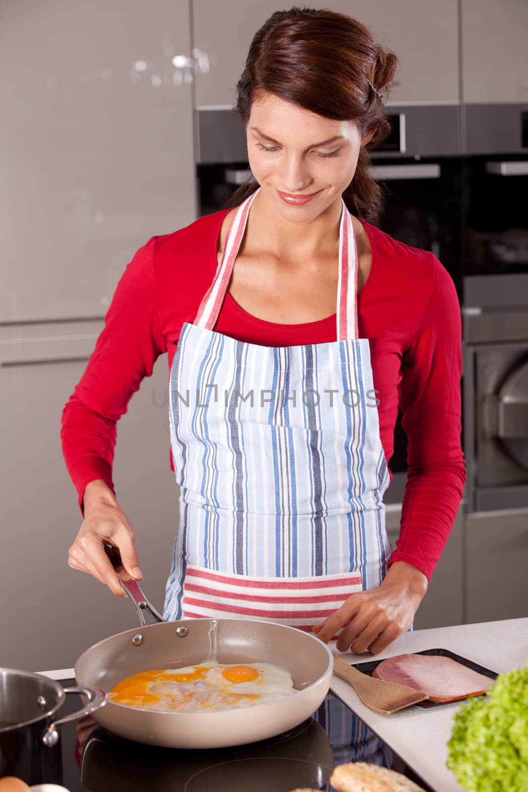 Woman preparing an egg in a frying pan