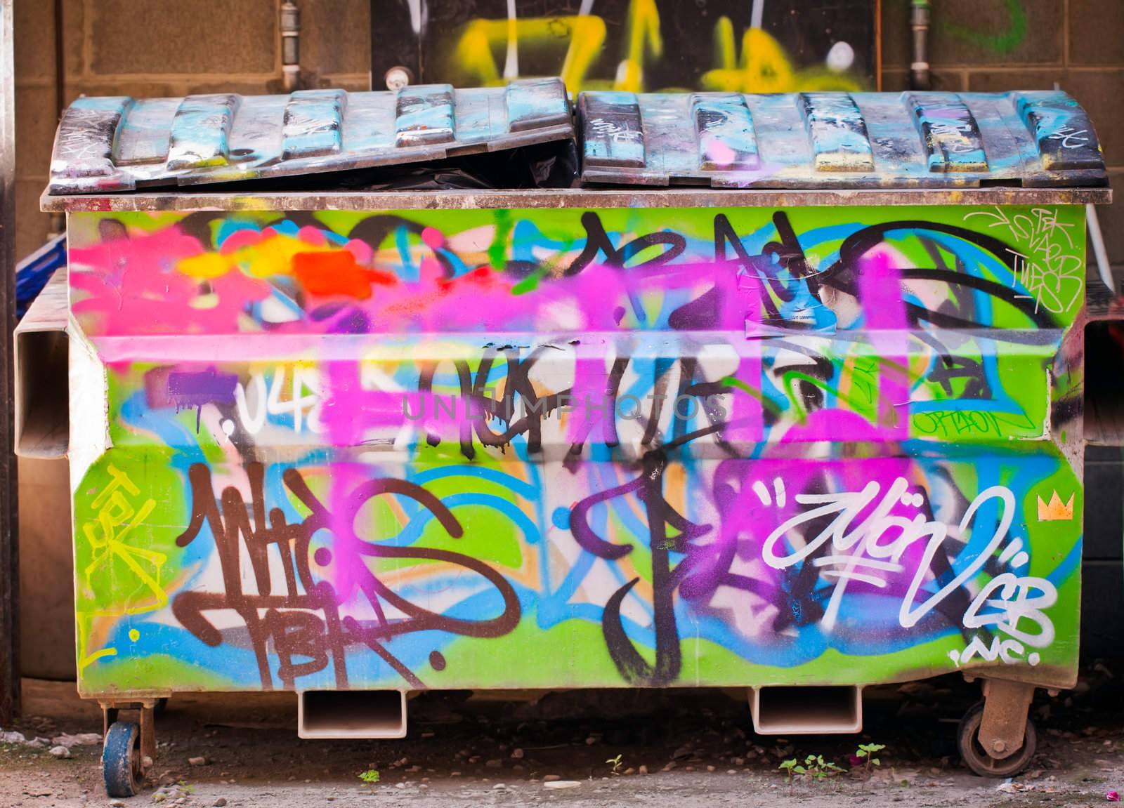 A rubbish bin or dumpster full of trash and covered in graffiti by Jaykayl