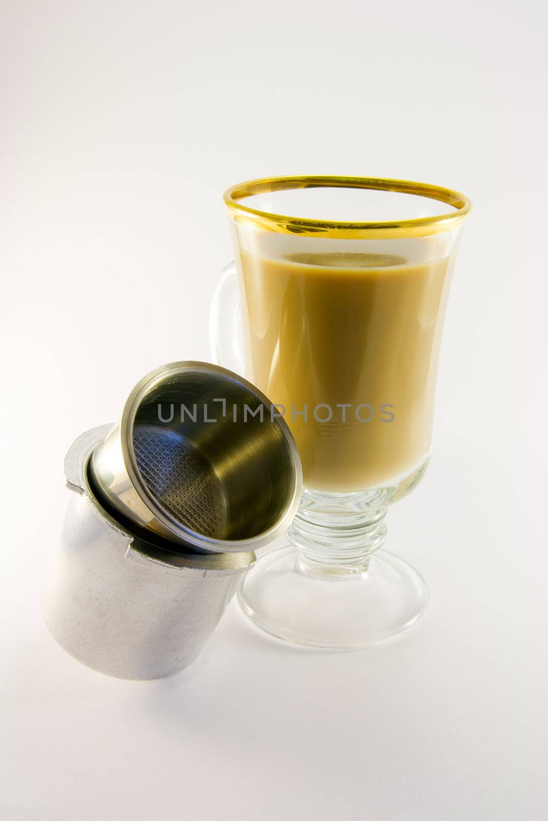 Latte in tall glass with coffee filter pan on a white background