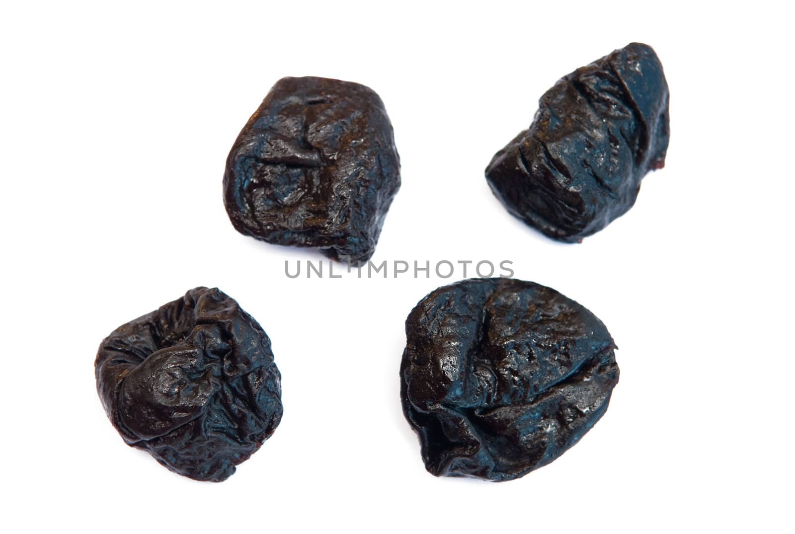 Four prunes isolated on the white