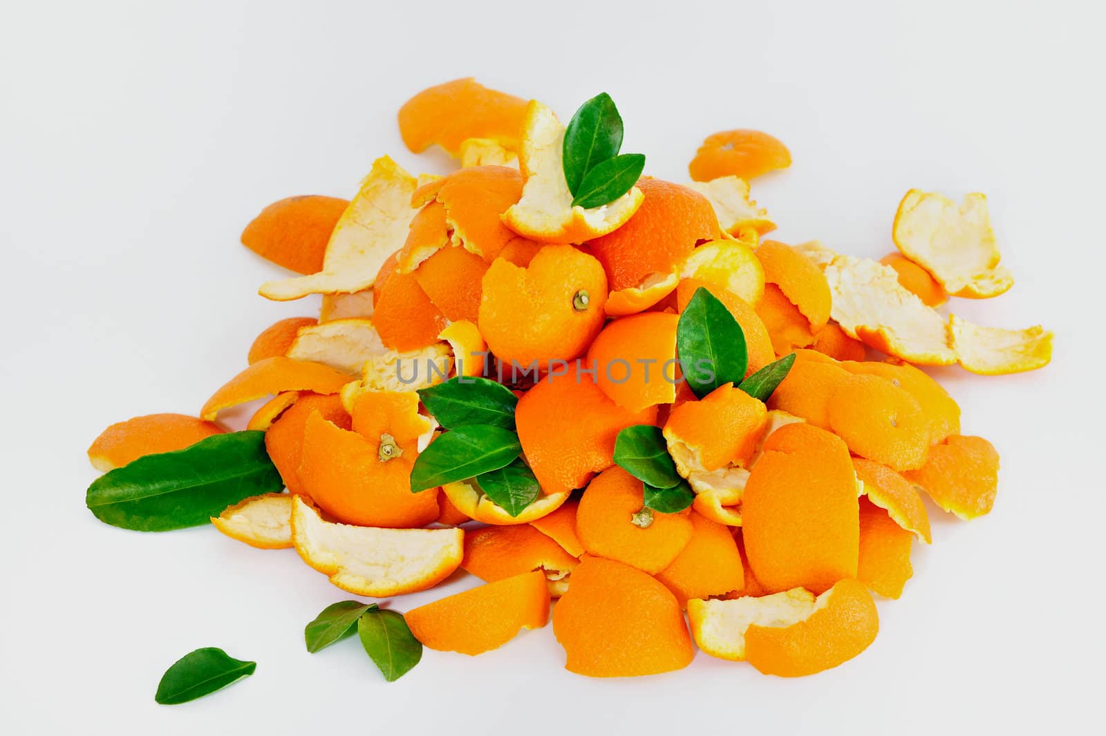 Peel of ripe oranges mixed with green leaves