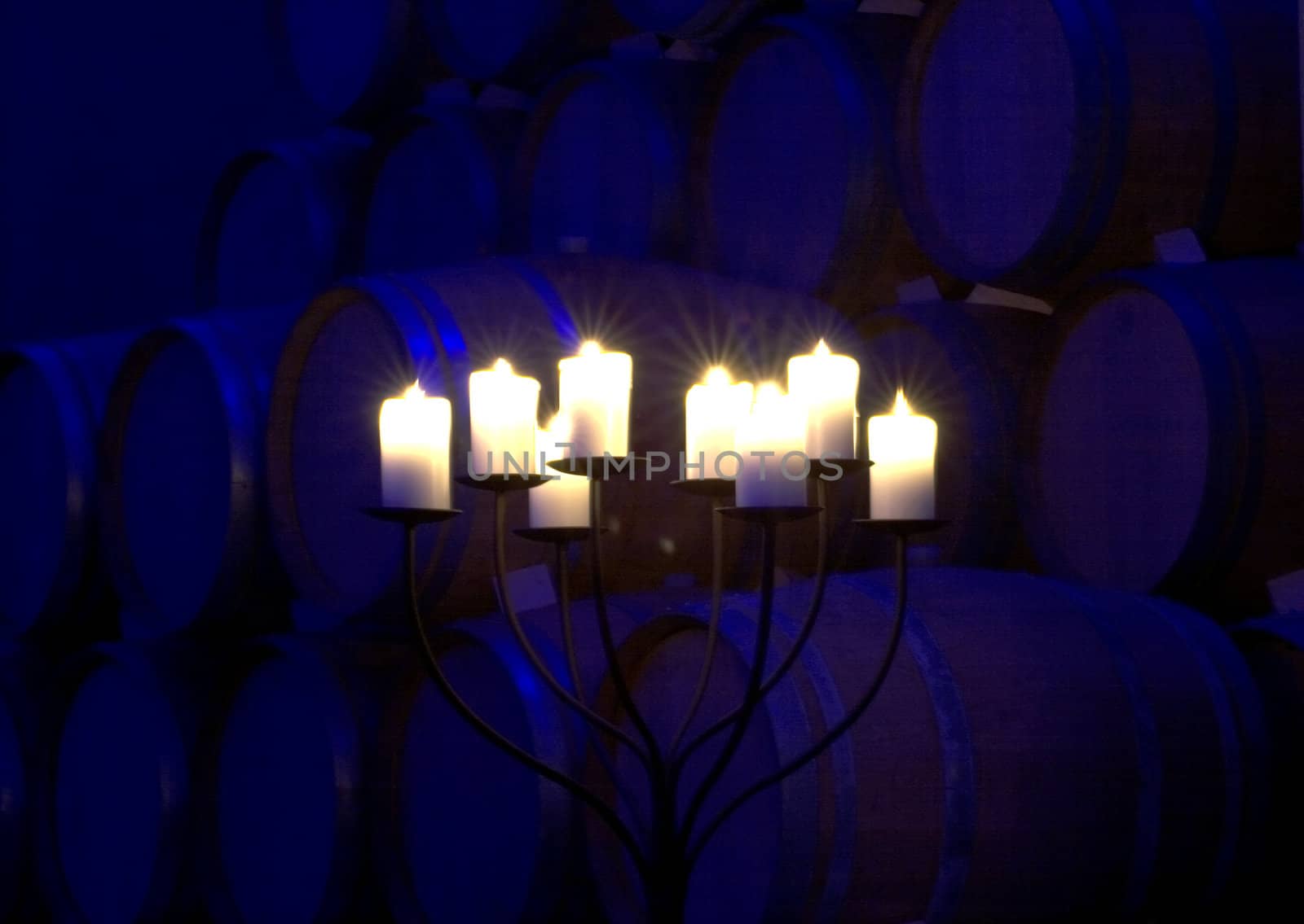 A cellar full of barrels with candles