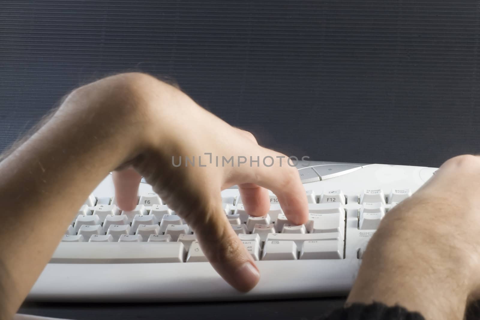 Male hands on white pc keyboard