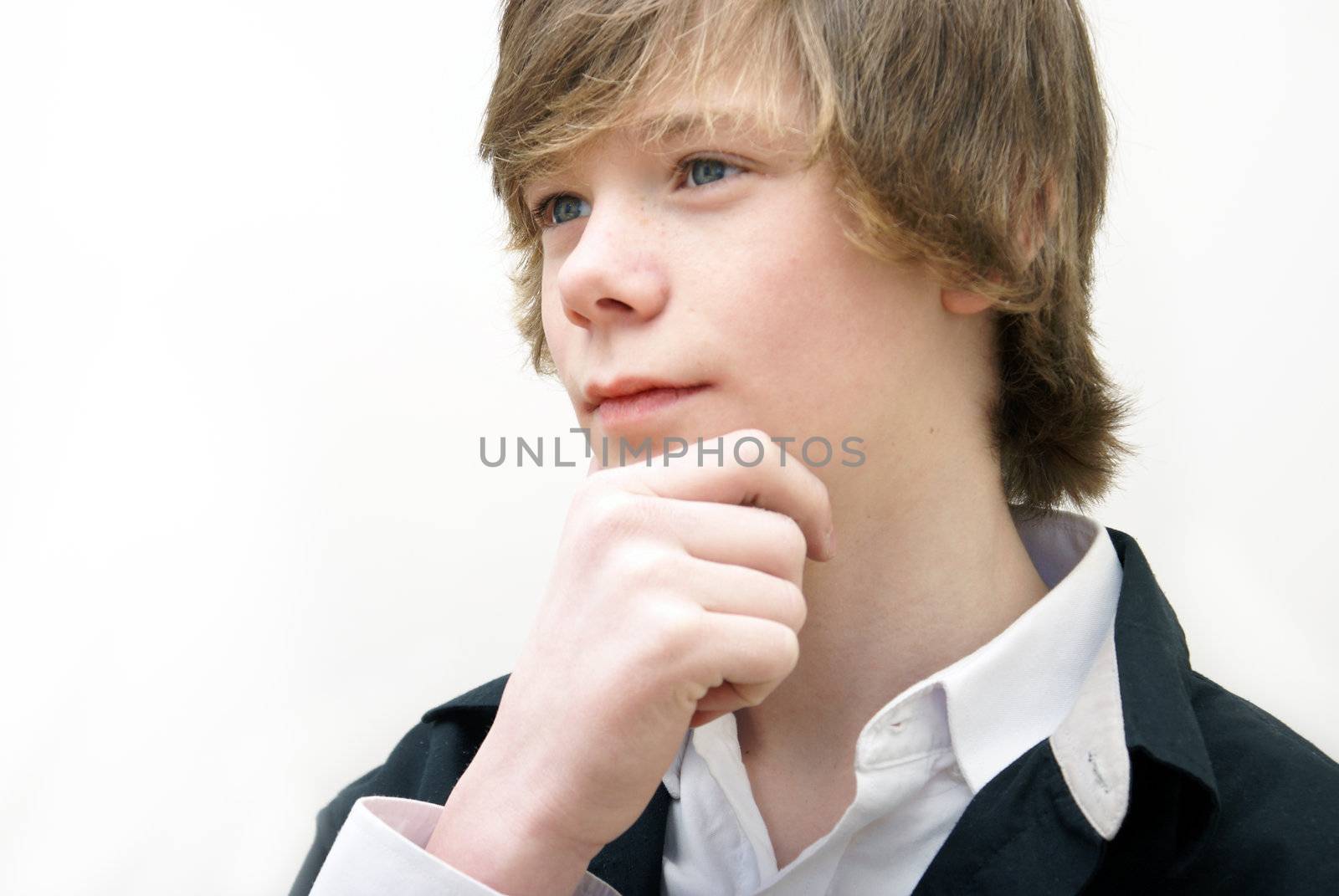 A teenage boy sits and thinks deeply.