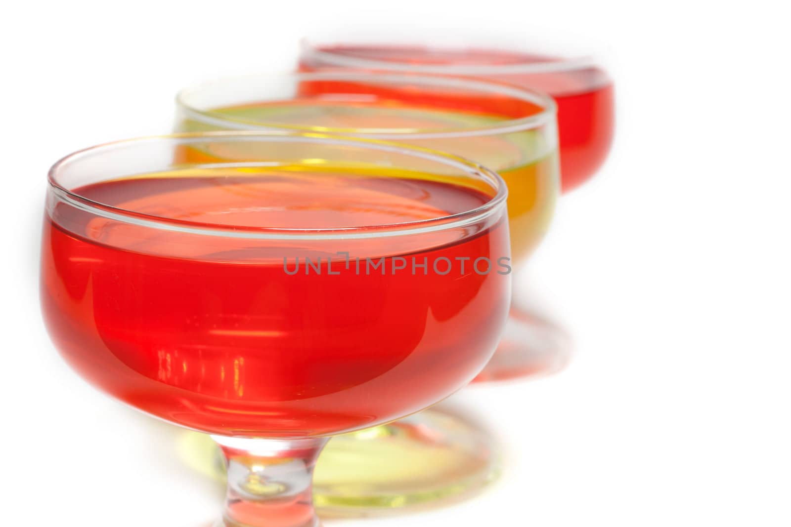 Yellow, red jelly in transparent glass stand on white background inline