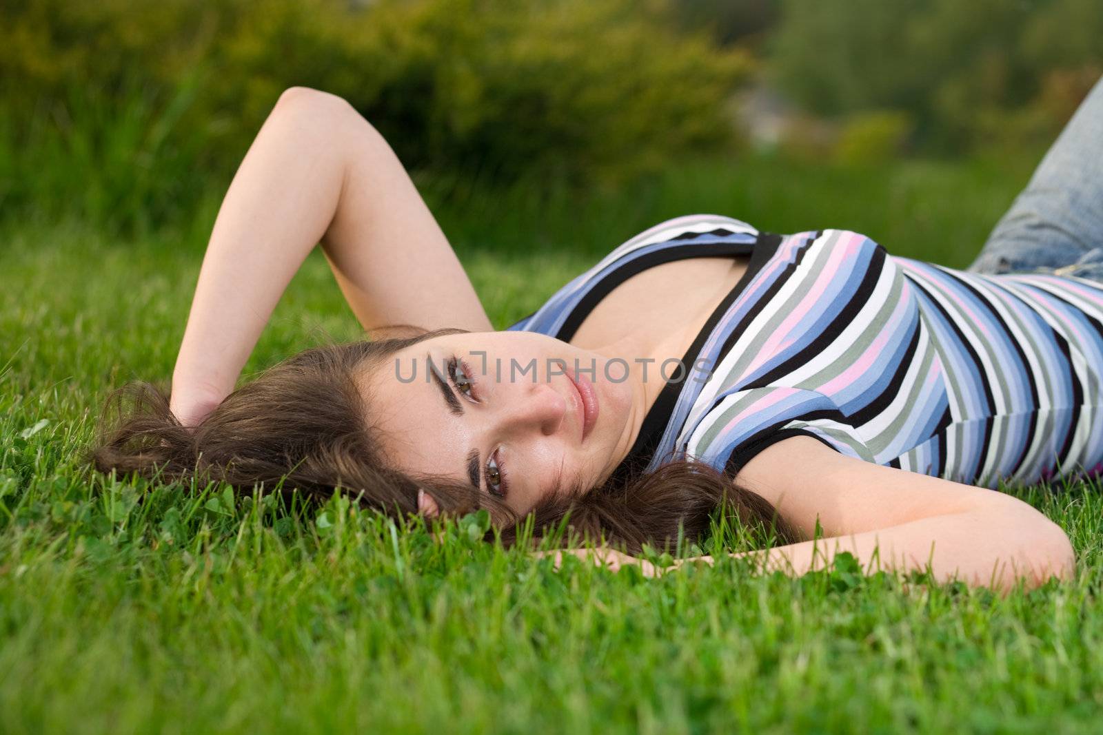 beautiful girl laying on freshcutted green grass