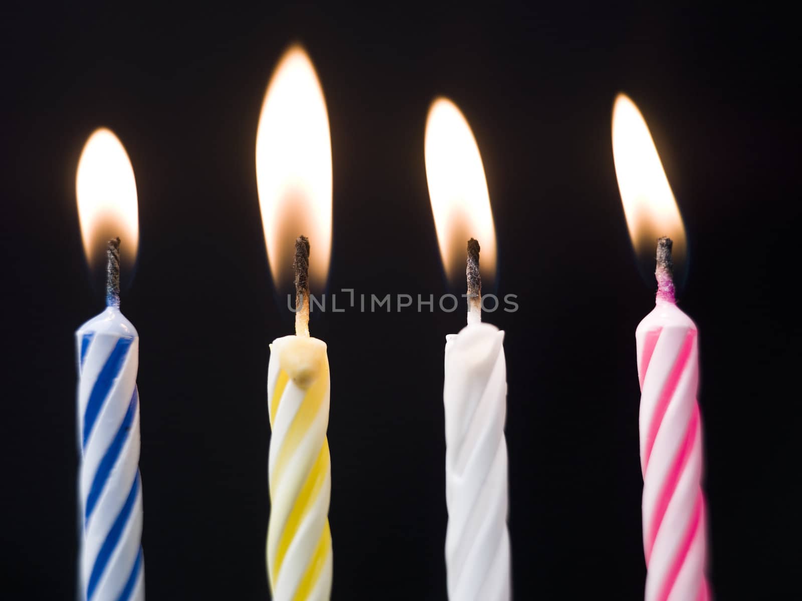Burning Birthday Candles on Black Background