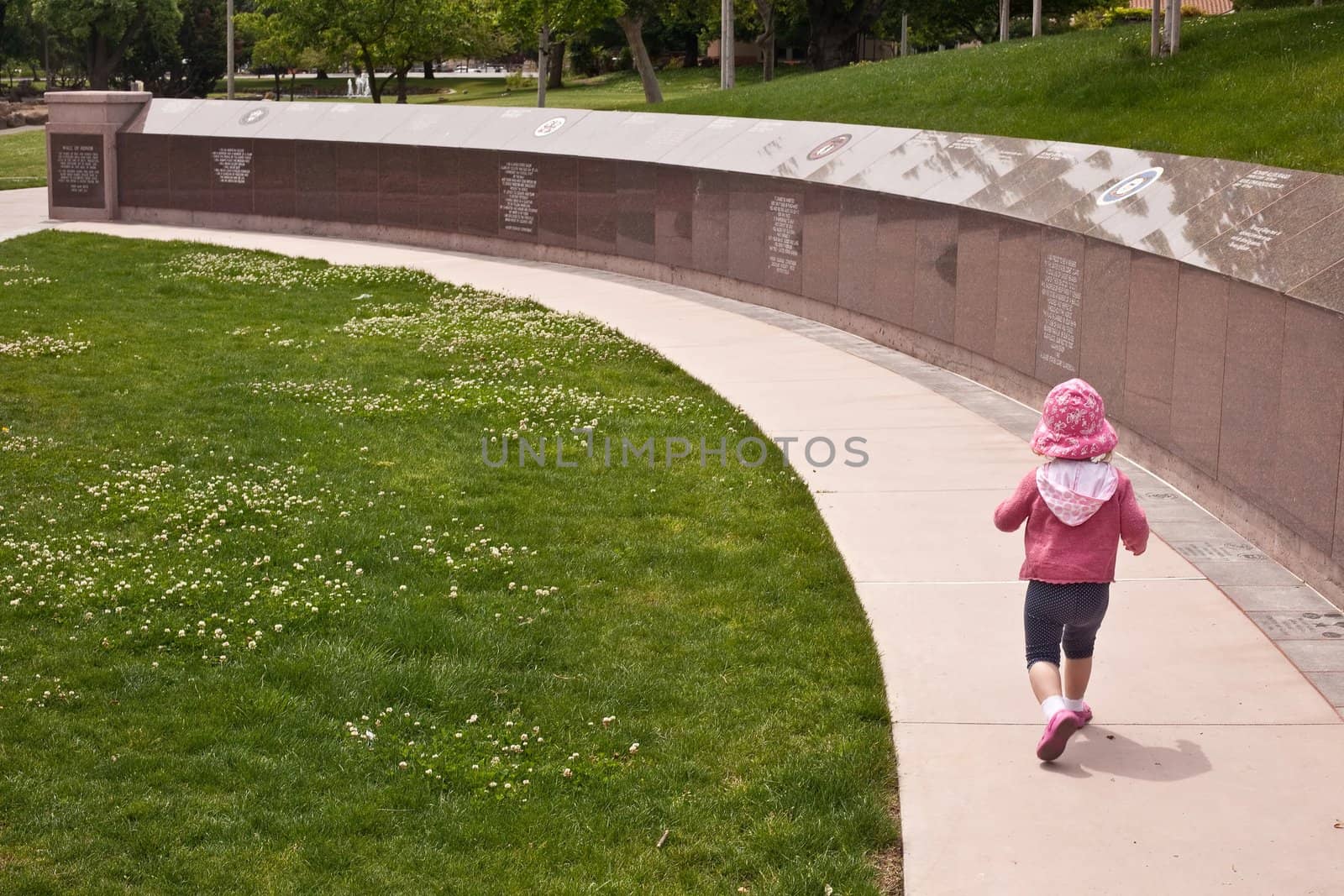 Cute caucasian toddler girl walking around and playing in the park