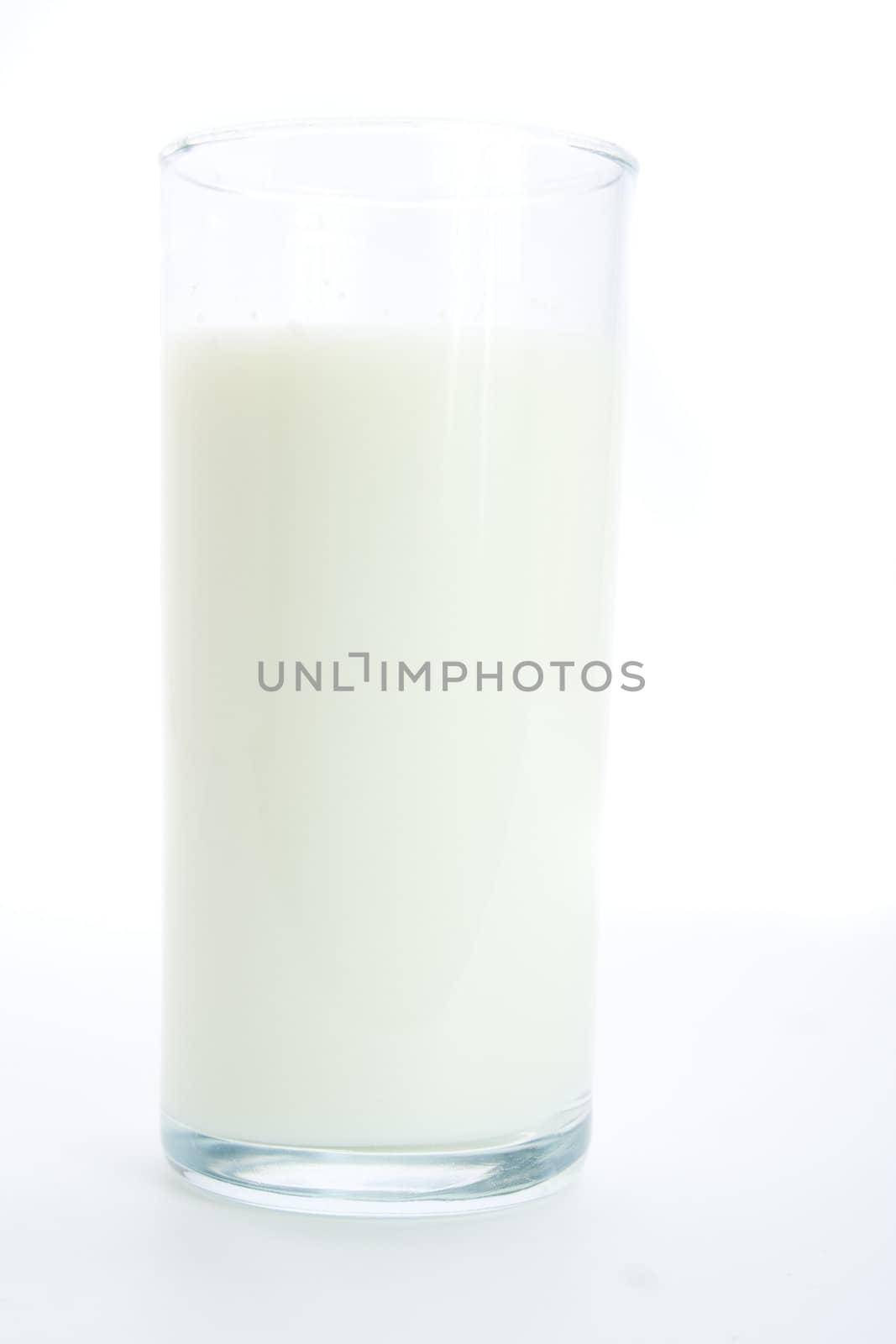 Glass of fresh milk isolated on white background with gentle shadows.