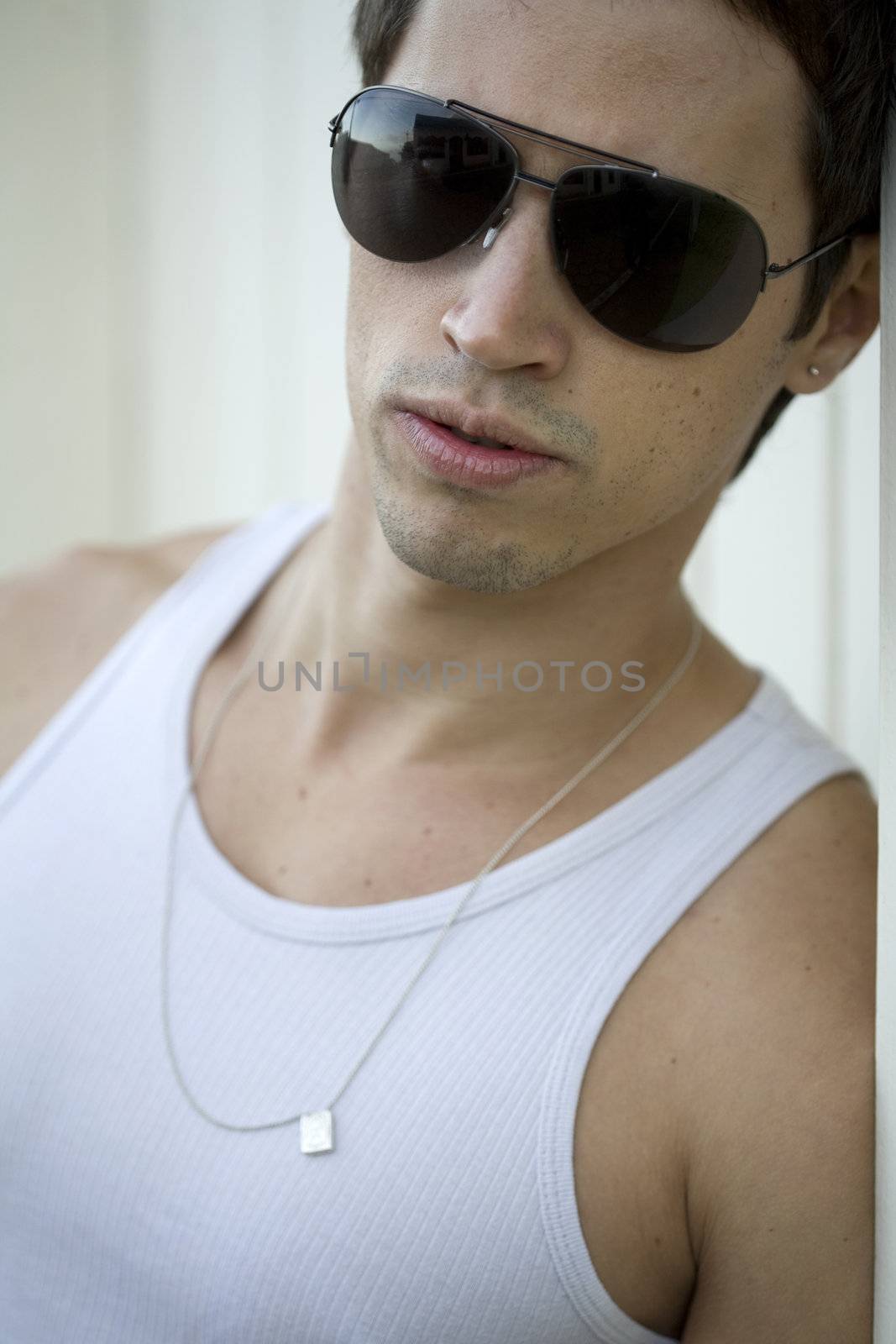 A young male model from Brazil in outdoors photograph, with aviator sunglasses.