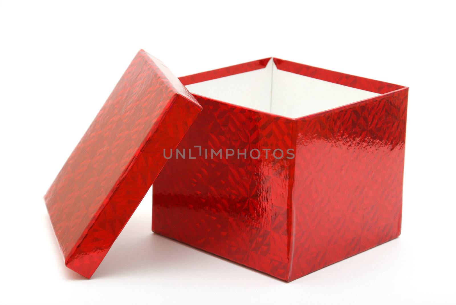 A single red gift box with the lid leaning on the side.