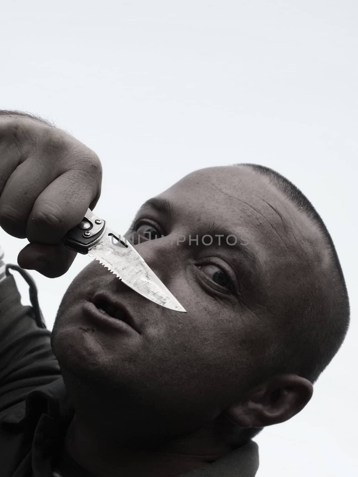 Portrait of a male thug brandishing a pocket knife