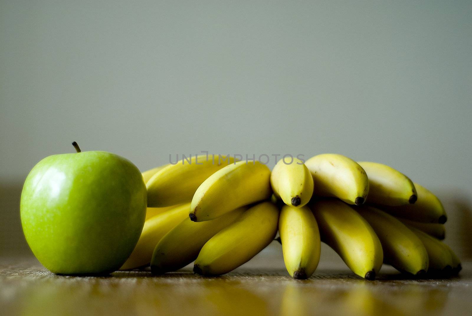 Still life with mini bananas and apple